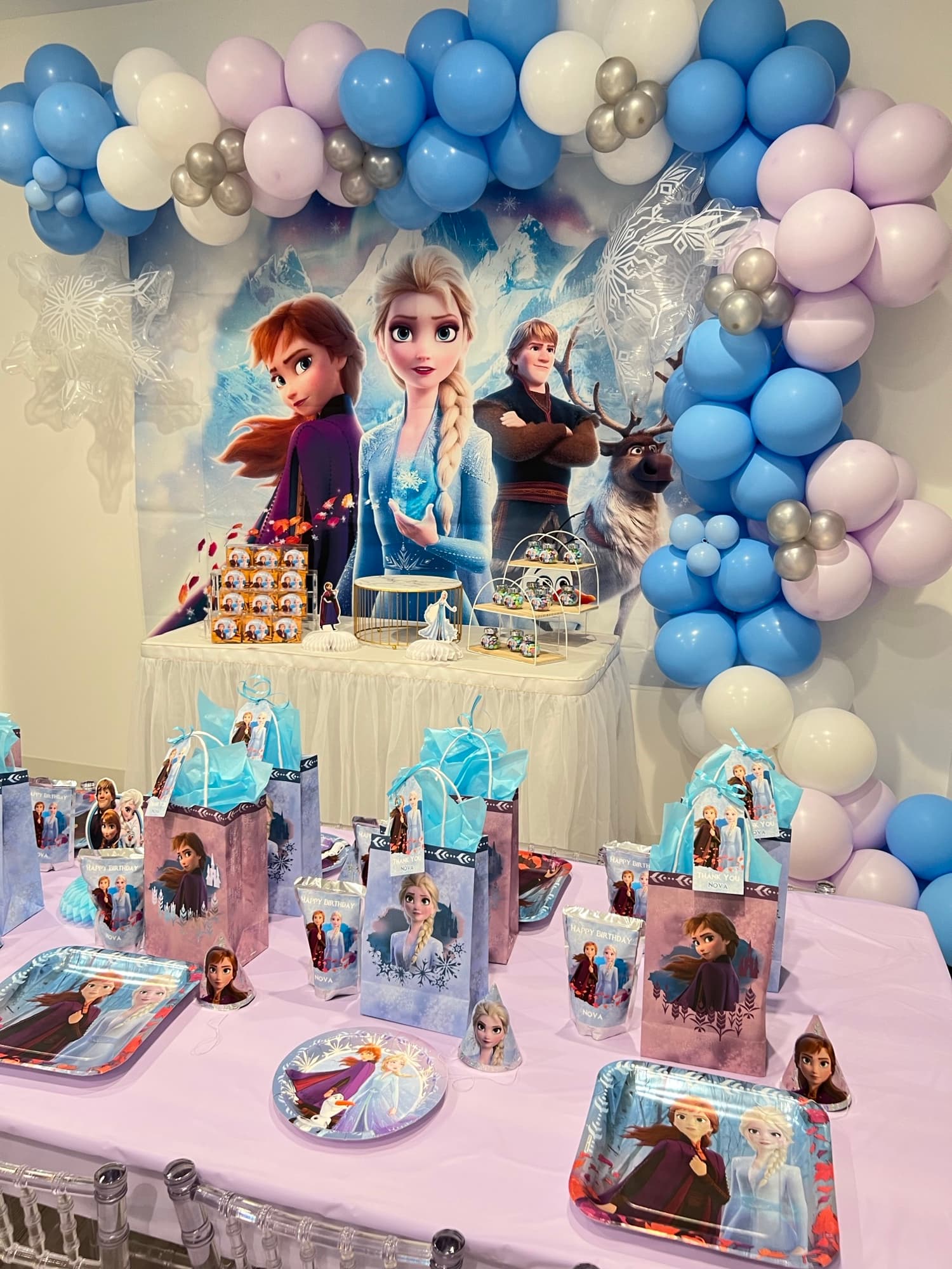 Buffet d’anniversaire Reine des Neiges avec ballons bleus et silhouettes de personnages