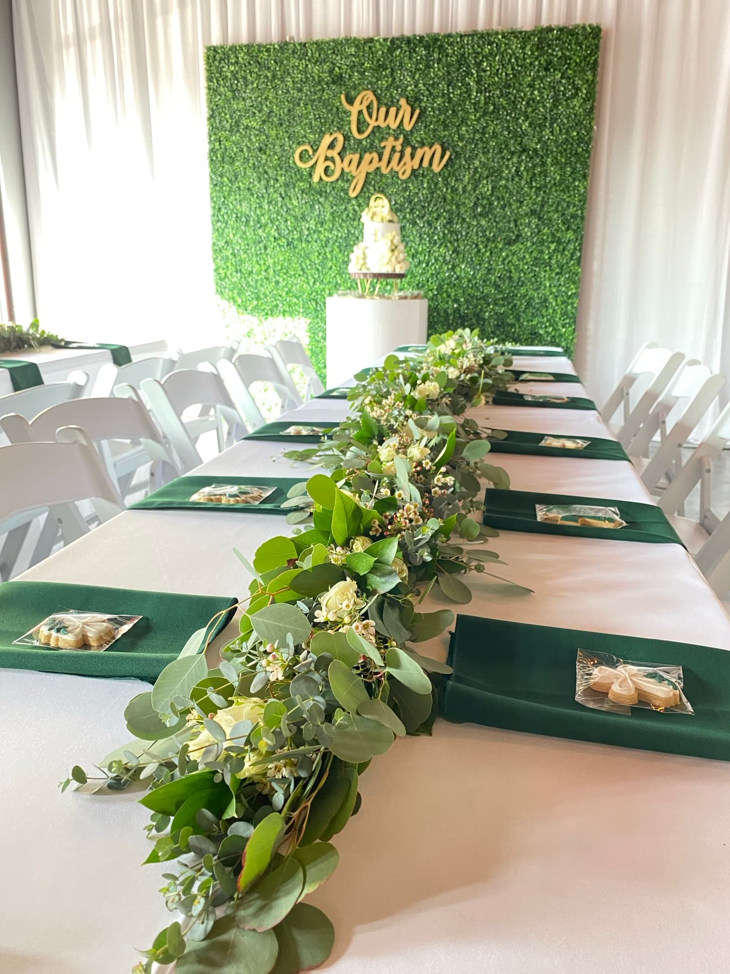 Longue table de fête verte et blanche avec centres de table végétaux