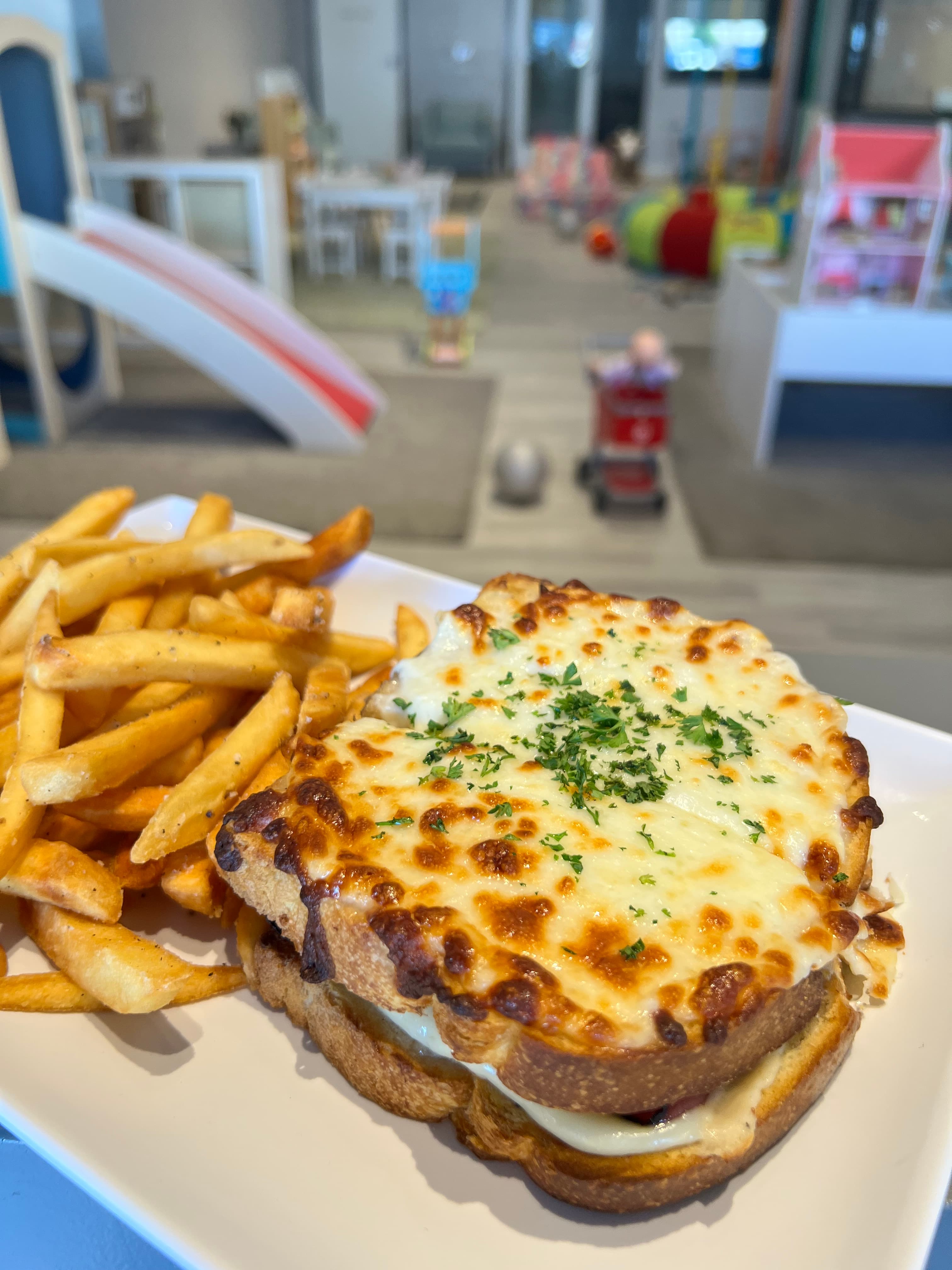 Croque monsieur sandwich with crispy fries plated at the family cafe