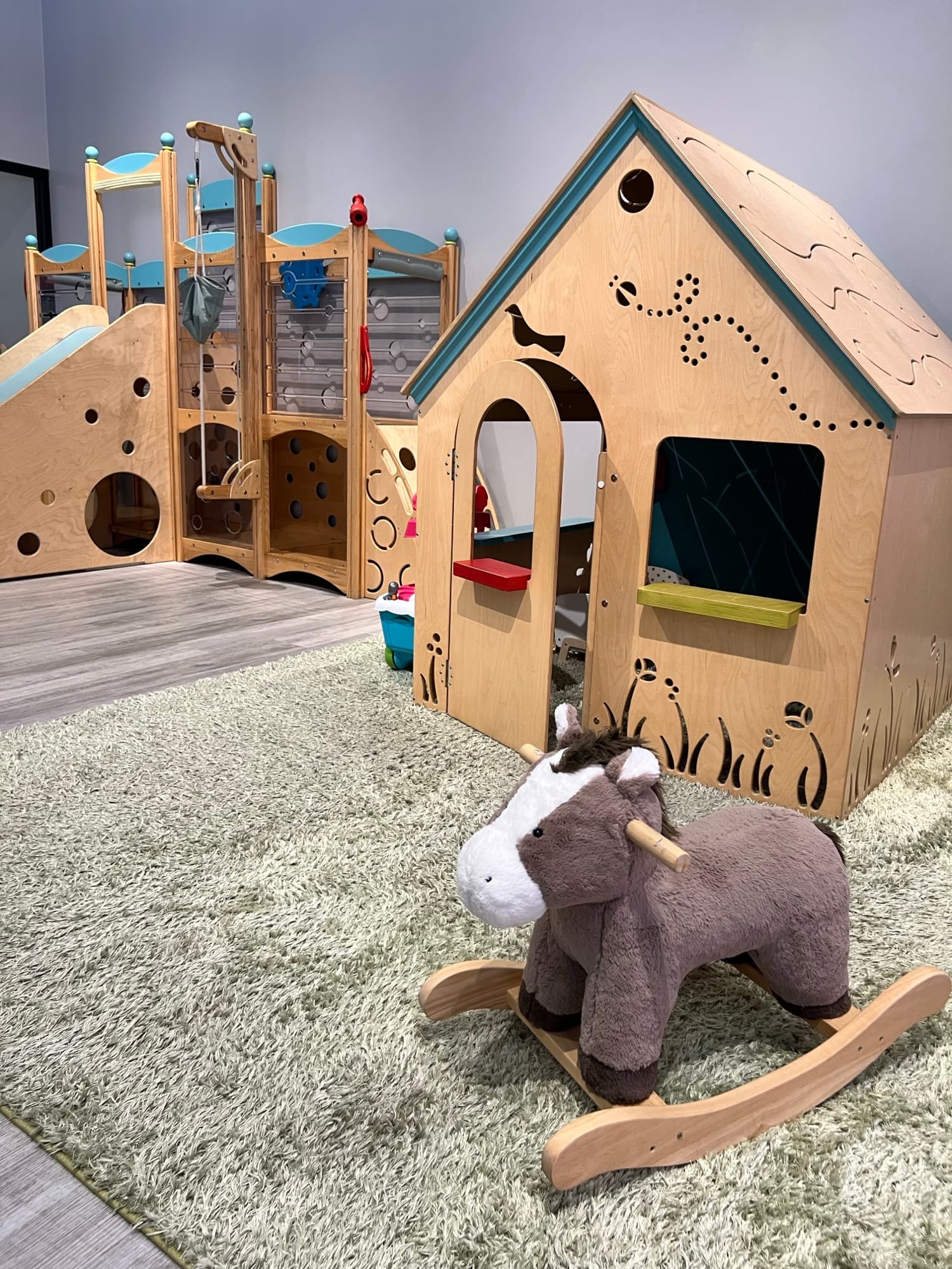 Wooden playhouse and soft elephant toy inside the children’s play area