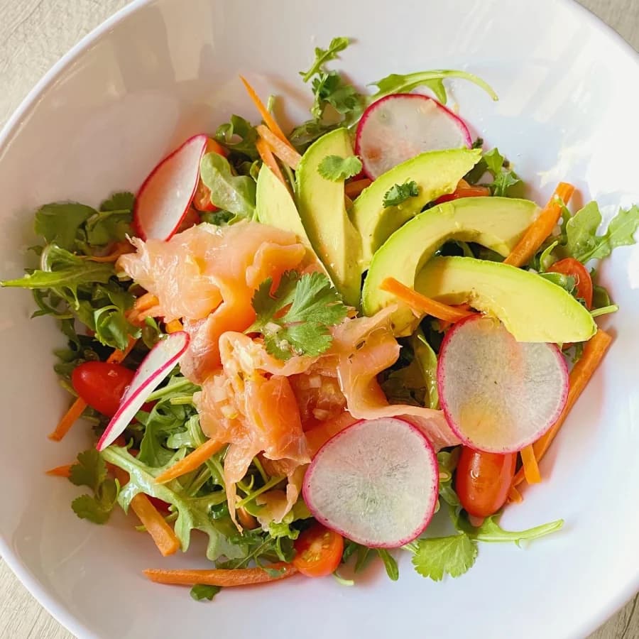 Une salade fraîche au saumon fumé, à l’avocat, aux radis et aux jeunes pousses